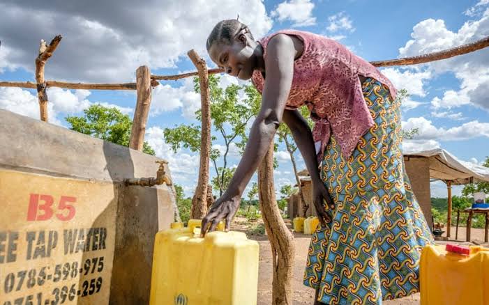 A woman filling a jerrycan at a community water point